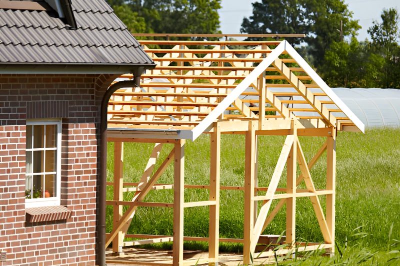 shed construction next to a house with brick walls
